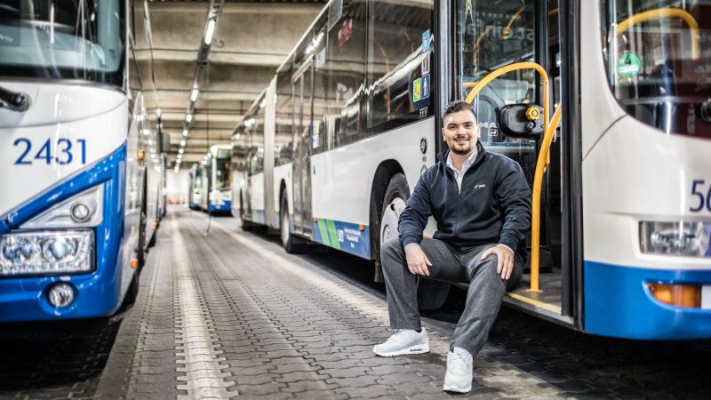 Ein Busfahrer sitzt im vorderen Eingang eines NIAG-Busses.